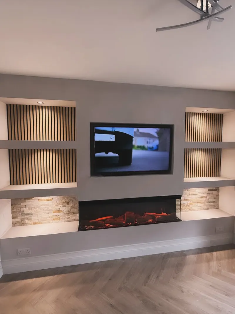 Media wall with a wall-mounted TV, an electric fire and lit alcoves with slatted panels