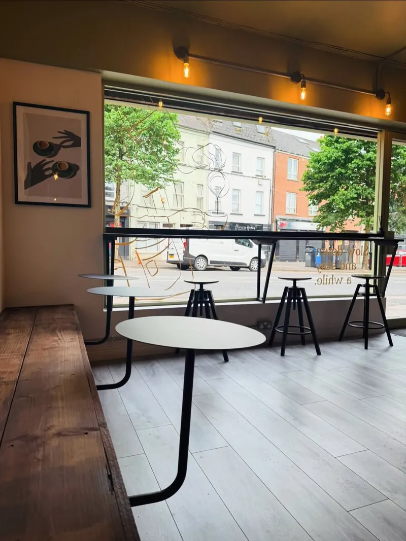 Window bar with stools and a row of filament bulbs on a ceiling-mounted track